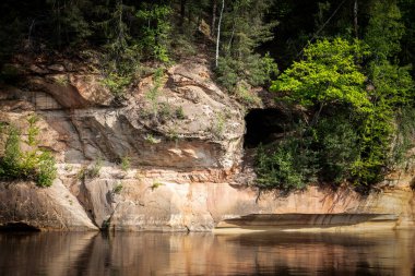 Ormandaki Kum Taşı Mağarası ve Uçurum Duvarı Suyun Yansımalarıyla.