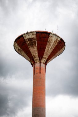 Bulutlu Gün 'de Eski Kırmızı ve Beyaz Su Kulesi Bulutlu Gökyüzüne Karşı.