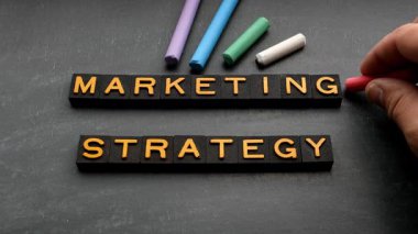 Pazarlama Stratejisi. Tahta zemin üzerinde alfabe harfleri ve tebeşir parçaları. 4K Video