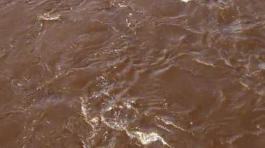 Doğal Gün Işığında Yansıma ve Akış Şablonlarıyla Çalkantılı Kahverengi Nehir Suyu