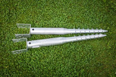 Yeşil Çim Üst Görünümü üzerine Bağlanan Parantez ile Metal Zemin Vidaları.