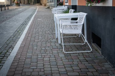 Cobblestone Caddesi 'ndeki Beyaz Hasır Sandalyeli Boş Açık Cafe Terası.