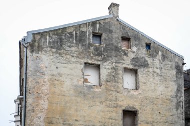 Old Building Wall with Exposed Brick and Empty Windows.
