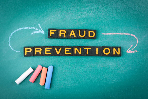 Fraud Prevention Concept with Chalkboard and Letter Tiles.