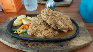 Biftek ve un. İçinde et, sığır eti, keçi, bufalo, at ve tavuk menüleri olan yemekler. Masadaki ısıya dayanıklı konteynırda servis edilmiş. Mutfak kavramları için lezzetli yemekler.