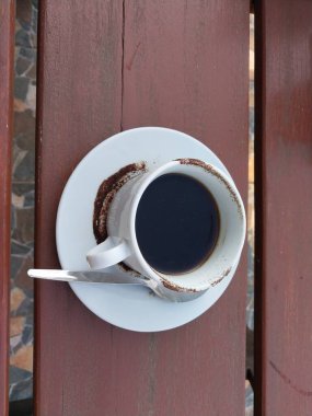 Beyaz fincanda sade kahve. Masanın üstü görünüyor. Günün tadını çıkarmak için kafe içkisi menüsü konsepti. Kahve lekeli fincan.