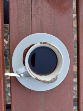 Beyaz fincanda sade kahve. Masanın üstü görünüyor. Günün tadını çıkarmak için kafe içkisi menüsü konsepti. Kahve lekeli fincan.