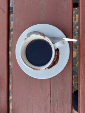 Beyaz fincanda sade kahve. Masanın üstü görünüyor. Günün tadını çıkarmak için kafe içkisi menüsü konsepti. Kahve lekeli fincan.