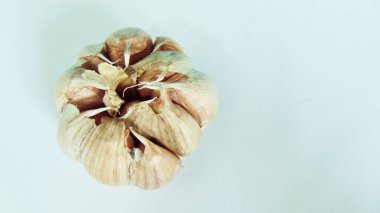 Sarımsaklı beyaz arka plan. Sarımsak, Asya 'nın temel baharatlarından biri olan birçok faydasıyla bilinir. Sarımsak, vücuda iyi gelen antioksidan açısından zengin olarak bilinir. Sağlıklı gıda kavramı