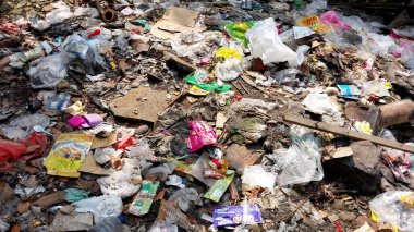 Çürümemiş çöp yığınları. Plastik çöpler bahçeyi dolduruyor. Çevre kirliliği kavramı. Çöpün arka planı