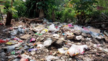 Çürümemiş çöp yığınları. Plastik çöpler bahçeyi dolduruyor. Çevre kirliliği kavramı. Çöpün arka planı