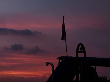 Teknedeki ufuk manzarası. Gün batımı. Deniz ve gökyüzünün güzelliğinin arkaplanı turuncuya dönmeye başlıyor. Güneş batıyor, gökyüzü renklerle dolu..