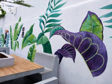 Painting on white wall. Mural art to decorate the wall to make it more attractive. Art industry and meaningful graffiti. Painting work in the room