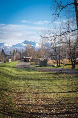 Çok katlı apartmanlara ve Anchorage 'daki Spenard Gölü yakınlarında Chugach Dağı' nın arka planında bulunan ticari binalara giden Hillside yolu. Yüzen uçaklar ve Ekim başında Alaska 'da manzara