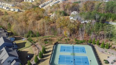 Atlanta, Georgia, ABD 'nin varoşlarındaki yemyeşil yemyeşil parkın yakınlarında sıralı evler ve iki tenis kortuyla hava manzarası yayıldı. Banliyö yerleşim alanı topluluk büyük arka bahçe