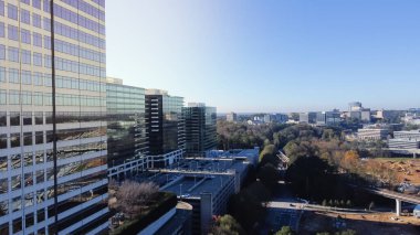 Atlanta 'daki I-85 otoyolunun yanında modern gökdelen ofis binasının yanında çalışan ağır makineler bulunan hava manzaralı büyük otoyol inşası. Çok katlı garaj