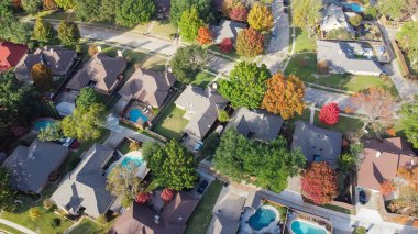 Upscale single family home with swimming pool and colorful fall foliage near Dallas, Texas, America. Aerial view an established suburban residential neighborhood bright autumn leaves, large street clipart