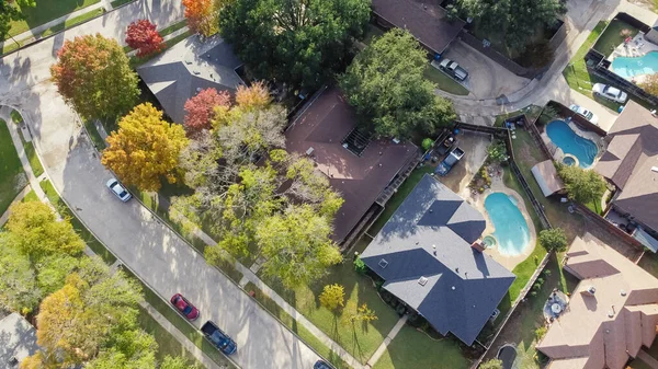stock image Upscale single family home with swimming pool and colorful fall foliage near Dallas, Texas, America. Aerial view an established suburban residential neighborhood bright autumn leaves, large street