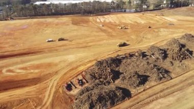Hava görüntüsü, ABD 'nin Georgia eyaletinin Buford kentindeki Gravel Springs Yolu yakınlarındaki büyük bir depo inşaatı projesi için toprak taşıma çalışmaları yapan ağır makinelerle meşgul. Endüstriyel ulaşım videosu