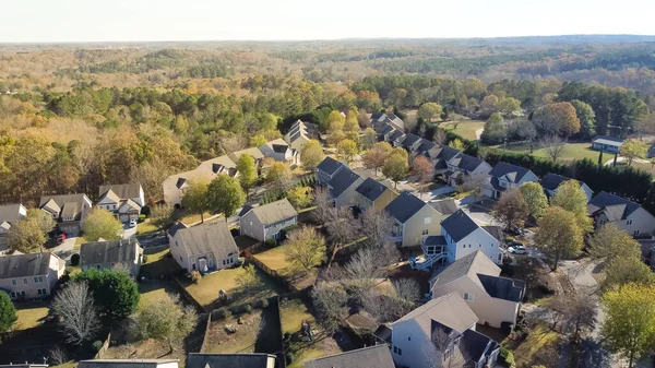 Residential neighborhood master-planned community and subdivision sprawl in woodland area with tall mature trees and Chestnut Mountain background. Aerial view two story house suburbs Atlanta, GA, US