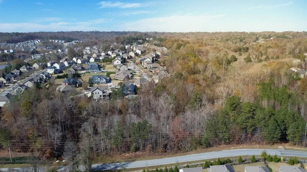 Ustaca planlanan yeni yerleşim bölgeleri boyunca uzanan servis yolu Atlanta, Georgia, ABD 'de bulunan mavi gökyüzü banliyölerine uzanır. Hava manzaralı iki katlı evler garajın önünde.