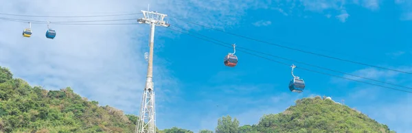 Panorama view gondola lift support tower with cable cars and Nui Lon mountain background in Vung Tau, Vietnam. Steel and tubular framework pylon for aerial tramway to Ho May Park tourist attraction