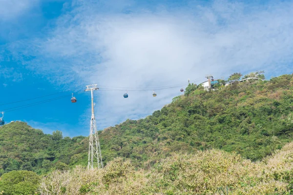 Gondola lift support tower carry cable cars approaching entrance of Ho May Park tourist attraction at Nui Lon mountain, Vung Tau, Vietnam. Steel tubular framework pylon for aerial tramway cloud sky