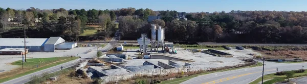 Panorama aerial ready-mixed concrete batching plant with cement silo, weigh hopper, conveyors, screw feeder and aggregates granular gravel, crushed stone. Industrial factory near highway Georgia, USA