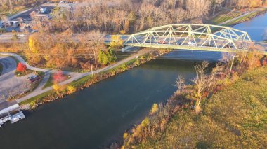 Industrial warehouse near historic Pratt through truss bridge over concrete pathway and Erie Canal in the Village Pittsford, New York. Aerial view landmark structure built in 1973 on State Route 96