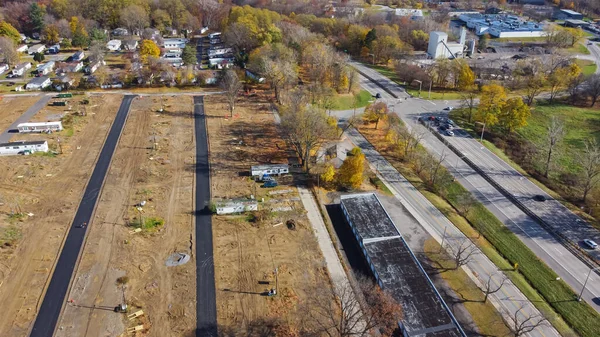 Warehouse storage near construction site of mobile trailer park with infrastructure onsite concrete slab grade foundation support works in Upstate New York. Aerial trailer park concrete road, sewer