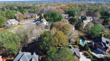 Upscale houses with swimming pool situated in leafy suburb residential neighborhood with cul-de-sac and lush green trees near Atlanta, Georgia, US. Aerial view master planning subdivision urban forest