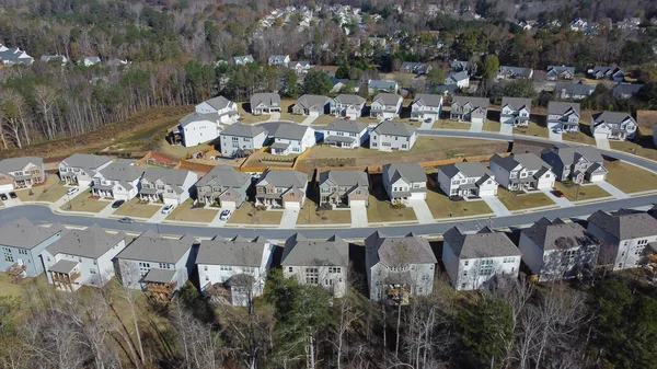 Aerial view master planned community row of new development three story houses surrounded by woodland lush tree area outside Atlanta, Georgia, USA. Upscale homes with well-trimmed lawn, front garage