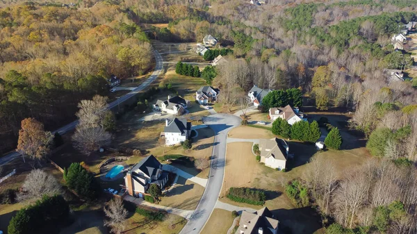 Lush suburban area forest park, low density residential of several dwelling units per acre, two-story houses with swimming pool, no-fenced yards near Atlanta, Georgia, USA. Aerial view wealthy homes