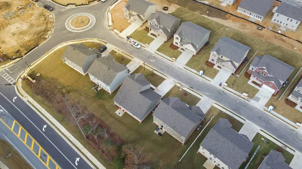 stock image Medium density neighborhood with new development dwelling units houses near roundabout traffic circle residential area in Flowery Branch, Georgia, USA. Aerial view subdivision homes front garage