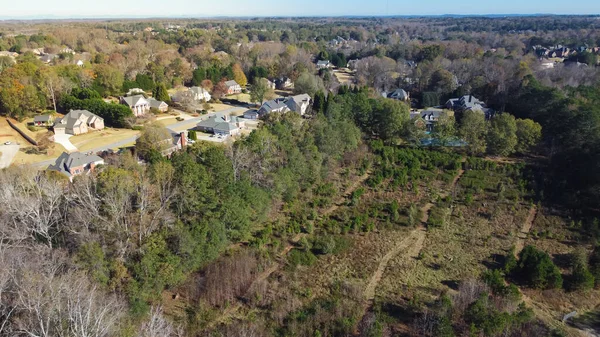 Low density housing residential area with Chestnut Mountain in distance background, row of upscale multistory single-family homes in Flowery Branch, Georgia, USA. Aerial view suburban detached houses
