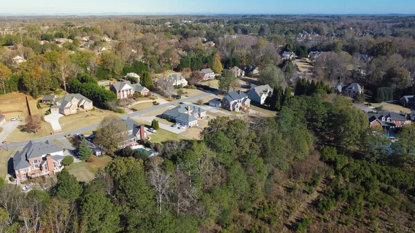 Low density housing residential area with Chestnut Mountain in distance background, row of upscale multistory single-family homes in Flowery Branch, Georgia, USA. Aerial view suburban detached houses