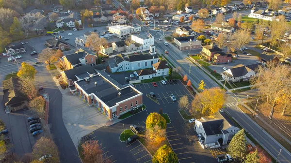 Penfield Road and Five Mile Line Street intersection in downtown Penfield with colorful fall foliage, County of Monroe, Upstate New York, USA. Aerial view local business building, churches, houses