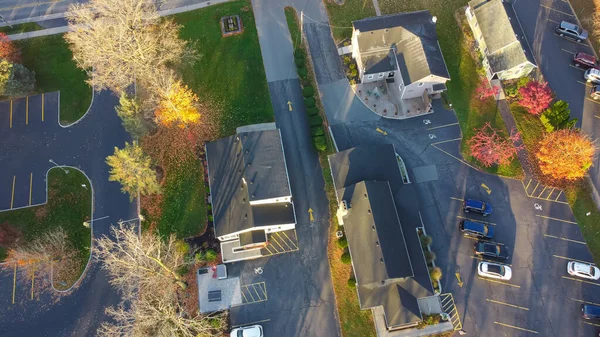 stock image Local business buildings with vacant parking lots and colorful autumn leaves in small town Penfield, Upstate New York, America. Aerial view beautiful fall foliage in historic town USA, morning light