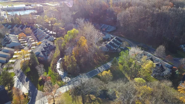 stock image Lakeside apartment complex near nature park with colorful fall foliage, evergreen and dormant trees in Rochester, Upstate New York, USA. Aerial view rental townhomes unit colorful autumn leaves