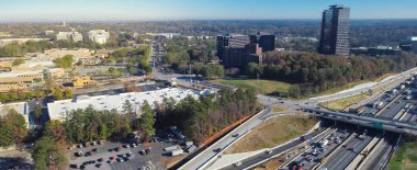 Panorama manzaralı yoğun bir trafik 285 numaralı çevre yolu, yüksek otoyol, ofis binaları yemyeşil Murphey Candler Park arka planı, Atlanta, Georgia. Havadan modern şehir