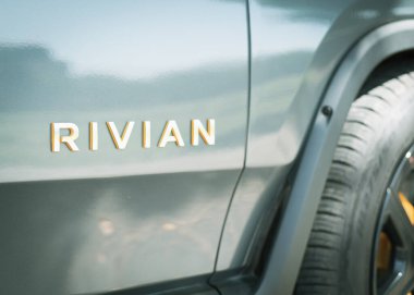 DUS, TX, ABD-APR 22, 2023: Dışarıya park etmiş yepyeni elektrikli araç R1T kamyonetinin yolcu kapısında geleceğin RIVIAN marka metni. Elektrikli, pille çalışan hafif görev kamyonu.