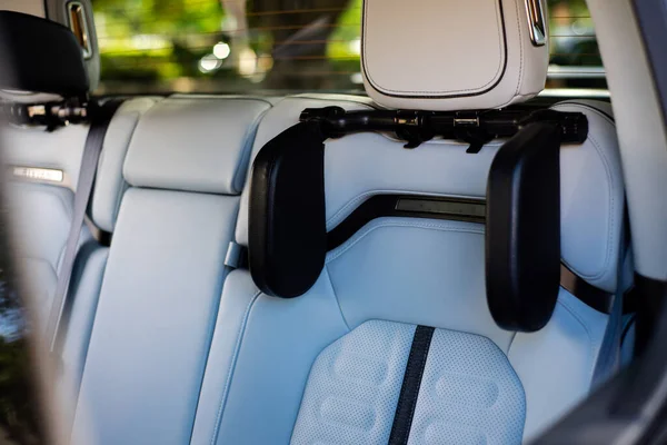 Passenger row of new pickup truck with neck pillow cushion rest back on leather-like finish artificial leather. Interior of luxury car