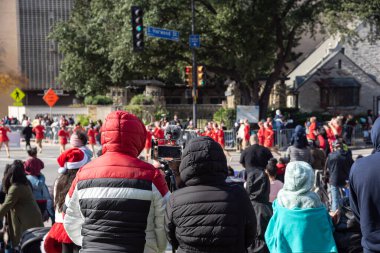 Sıcak giysi ceketi giyen ve canlı yayın yapan bir grup insan Dallas, Teksas, Amerika 'da canlı yayın yapan, canlı yayın yapan bir sokak performansı etkinliği izliyorlar. Kış festivali açık havada