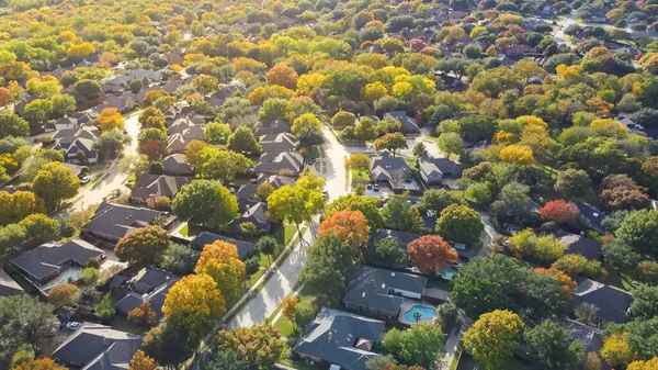 stock image Lush greenery master planned community subdivision colorful fall leaves and row of single-family homes with swimming pool in upscale neighborhood Dallas, North Texas, USA. Aerial view subdivision