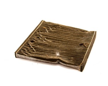 Kirlenmiş molozlarla kaplı kirli araba kabin hava filtresi beyaz arka planda izole edilmiş, çok lifli kağıt pamuk filtresi kullanılmış. Kullanılan hava filtresi