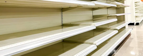 Panorama view empty shelves, peg boards at grocery stores, food shortage, pandemic, economic crisis or store closing in Dallas, Texas, USA. Clear sold-out goods groceries at retailer super market