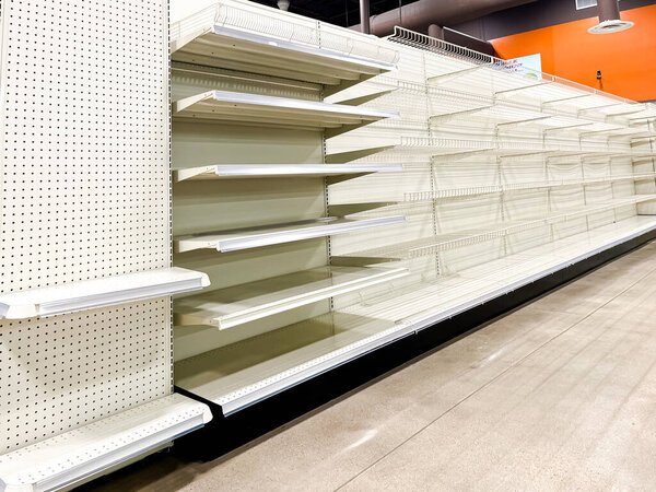 Большая пустая доска и ряд полок в продуктовых магазинах, нехватка продовольствия, пандемия, экономический кризис или закрытие магазина в Далласе, штат Техас, США. Чистые распродаваемые продукты на розничном супермаркете