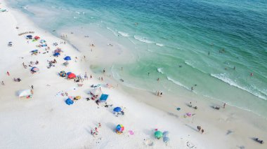 Colorful beach chairs, umbrellas and people swimming, relaxing laid-back, less crowded experience along white sandy beaches, turquoise water, gorgeous shade of blue Santa Rosa, Florida, USA. Aerial