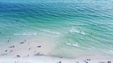Santa Rosa plajının muhteşem mavi ve kristal berrak turkuaz rengi, parlak beyaz kumlu kıyısı insanların yüzdüğü, rahatlatıcı, rahatlatıcı titreşimli Walton County, Florida, ABD. Havadan