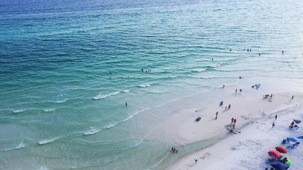 stock image Gorgeous shade of blue and crystal-clear turquoise water of Santa Rosa beach, brilliantly white sandy shore with people swimming, relaxing laid-back vibe charming Walton County, Florida, USA. Aerial